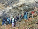 Students standing at the base of a cliff.