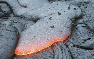 Image of a pillow basalt formation glowing red.
