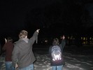 Photo of students pointing at an unseen object in the night sky.