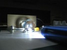 Photo of the projection of an LED flashlight through two lenses making images onto the paper backdrop.