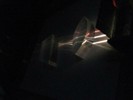 Photo of three beams of light curving as they pass through a trapezoidal-shaped and then lens-shaped glass.