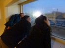 Photo of students observing the night sky through a high window.