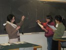 Photo of students holding a pendulum and drawing a pendulum diagram on the blackboard.