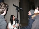 Photo of students setting up a telescope outdoors on a tripod.