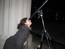 Photo of a student looking through the telescope at the moon.