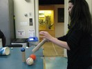 Photo of a student rolling a ball through a tipped tube.