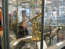 Photo of a student looking through a historical telescope on display in a glass case.