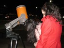 Photo of students observing the moon with the Celestron telescope oriented differently.