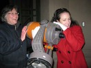 Photo of two students smiling while holding the reflector telescope.