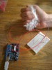 Photo of squeezing an early prototype, connected to the circuit board.