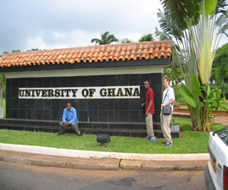 A photograph of three MIT students at the entrance of the University of Ghana.