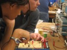 Two students observe their circuit's performance.