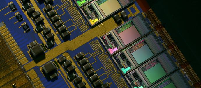 A close-up photo of a blue circuit board, mostly covered with multi-colored elements.