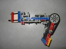 A Lego robot with a claw that opens in the plane of the table, and an arm that rotates perpendicular to the table.