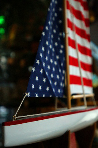 Photograph of a sailboat model with American flag motif sails.