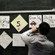 A student hangs signs in the classroom.
