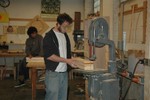 A student cuts a design profile from a wood block.