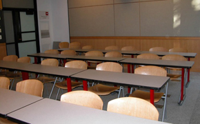 A photo of a classroom containing four rows of seats with six seats to a row.