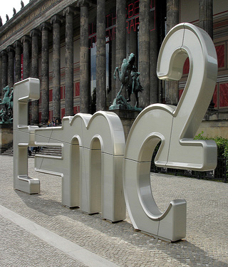 A photograph of a sculpture, which in large silver shapes forms Einstein's famous theory of relativity, "e = mc²."