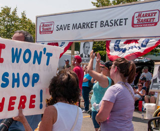 Protesters rally holding signs that read "save Market Basket" and "I won't shop here."