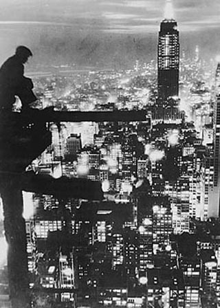Image of a man sitting high above New York City.