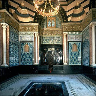 Arab Hall in the Leighton House Museum located in London shown with gold, blue and turquoise Islamic tile mosaics.