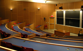 A large classroom for 100 students with tiered seating and several blackboards.