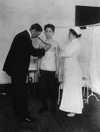 A black and white photograph of a man being examined by a doctor.