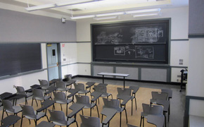 Photo of the classroom showing modern tablet armchairs and several blackboards.
