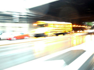 Photo of schoolbus on highway, blurred with speed.