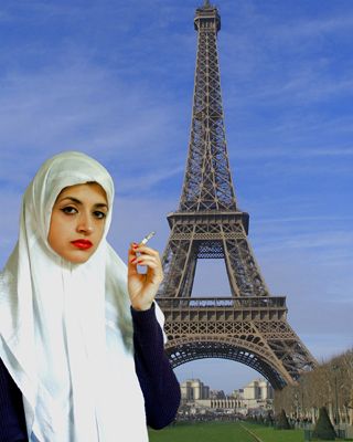 A woman wearing a chador head-scarf smokes a cigarette with the Eiffel Tower in the background.