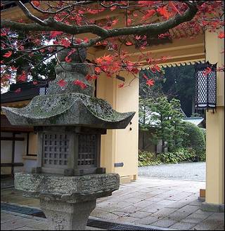 A photo of a temple on Mount Koya in Japan, showing a temple gate and a "toro."
