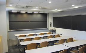 A small classroom with five rows of tables, each seating four.