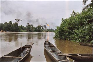 Photo showing canoes on a river with smoke in the background.