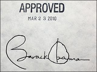 A photograph of a piece of paper, with President Barack Obama's signature at the bottom and a stamp above it that reads "APPROVED MAR 23 2010."