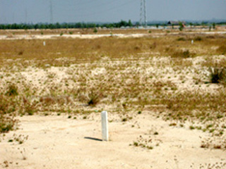 White boundary stones in an arid landscape, marking the boundary between public and private land.