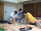 Three students working on one guitar.