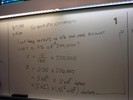 Notes on a whiteboard explain scientific notation.