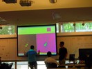 A student stands in front of a screen with an image projected on it.