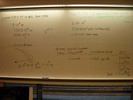 Notes on a whilteboard explain Calculations about linear diameter of blocking material.