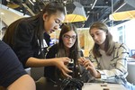 A photo of a group of girls helping each other with their camera builds.
